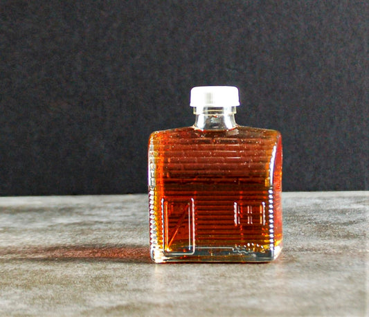 Maple syrup in a glass cabin bottle